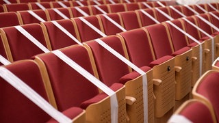 Mit Absperrband abgeklebte Sitze in einem Konzertsaal