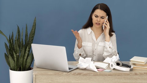 Gestresste Frau im Büro | Darf ich mein Kind im Notfall mit zur Arbeit nehmen?