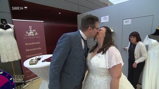 Küssendes Paar in Anzug und Brautkleid