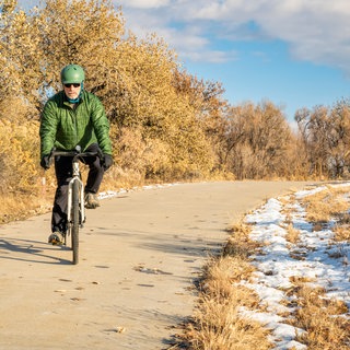 Mann fährt im Winter Fahrrad