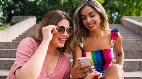 Zwei Freundinnen schauen auf ein Handy
