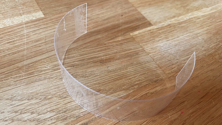 Aus dem Rest der Flasche ein gerades Stück (etwas 1,5 cm x 10 cm) ausschneiden. 