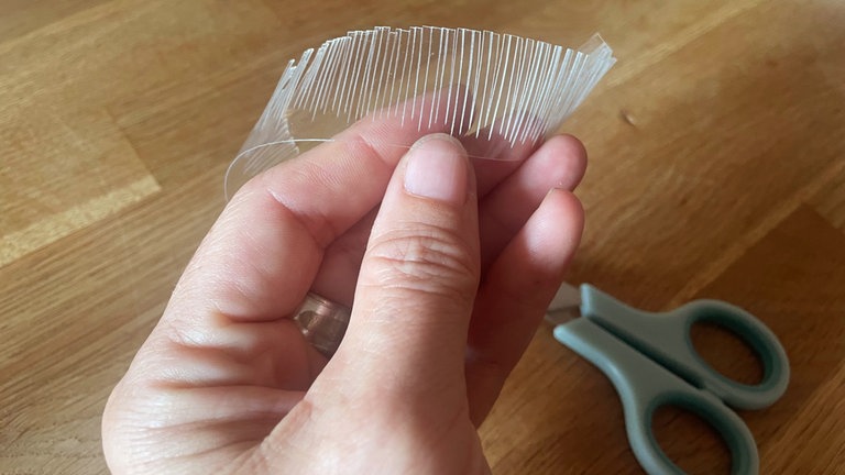 Dieses entlang der langen Kante in kleinen Abständen etwa je 1 cm tief fransig einschneiden. 