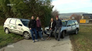 Zwei Paare stehen vor ihren Autos
