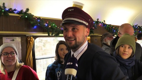Besucher bestellen sich Punsch im Stuttgarter Weihnachtszug
