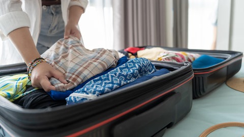 Eine Frau packt ihren Koffer | So packt ihr den Koffer für euren Urlaub richtig