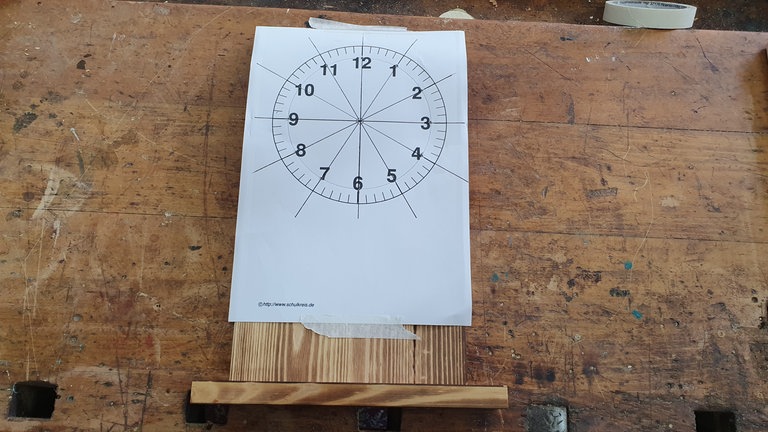 Uhrziffernblatt aus Papier auf Hauptbrett mit Malerkrepp befestigen