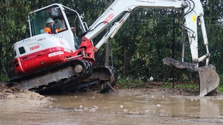 Ein Bagger bei Arbeiten im Schlamm