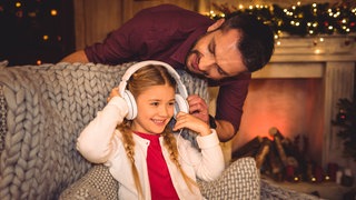 Ein Kind hört ein Hörbuch in weihnachtlicher Umgebung