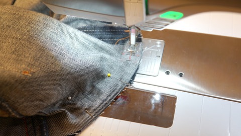 Das Feststeppen gelingt am besten, wenn der Kreis mit der linken Seite unten glatt auf dem Nähmaschinentisch liegt und das Seitenteil darüber. So hat man den besten Einfluss darauf, dass die Teile beim Steppen glatt zusammen kommen.