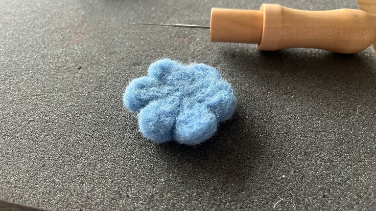 Damit sich die einzelnen Blütenblätter abheben, wird immer zwischen diesen von außen nach innen eine Linie gezogen. Hierfür solange mit der Nadel arbeiten, bis das gewünschte Ergebnis vorhanden ist. 