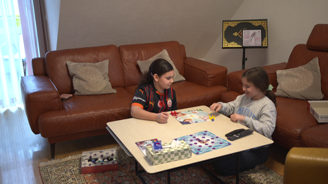 Zwei Mädchen spielen ein Spiel am Wohnzimmertisch