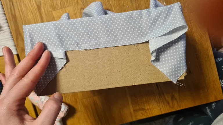 Wer zu viel Stoff übrig hat, kann diesen auch außen am oberen Rand festkleben.