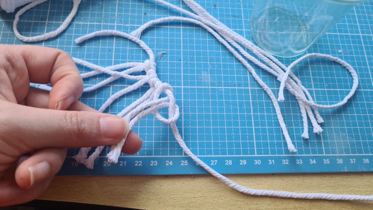 Im Abstand von etwa einem Zentimeter das Ganze wiederholen, bis rund um das Glas gleichmäßig solche Stränge befestigt sind.