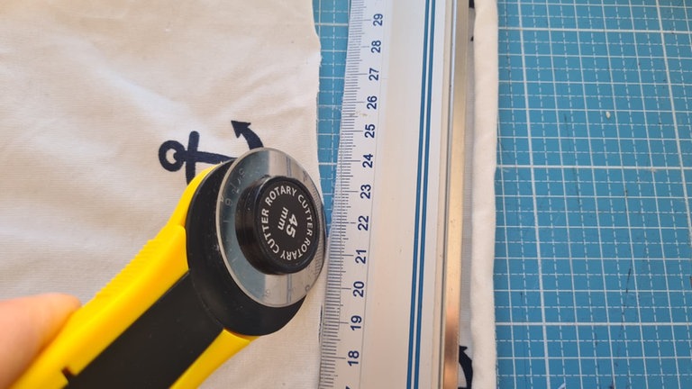 Den Stoff zuschneiden. Er sollte einmal um das Glas reichen und ca. 1 cm überlappen.