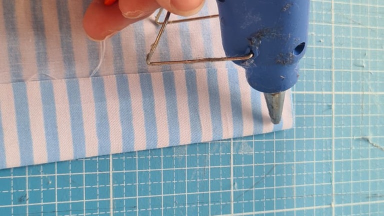 Die Stoffkante anschließend ca. 1 cm umschlagen und mit Heißkleber oder Bastelkleber bestreichen.