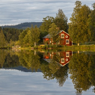 Rotes Holzhaus am See in Schweden