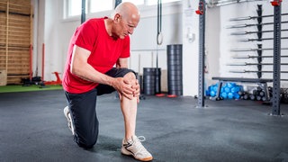 Mann beugt das Knie im Gym - Knieschmerzen müssen nicht sein