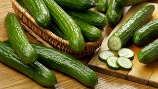 Frische Salatgurken im Korb und auf Schneidebrett | Darum sind Gurken so gesund