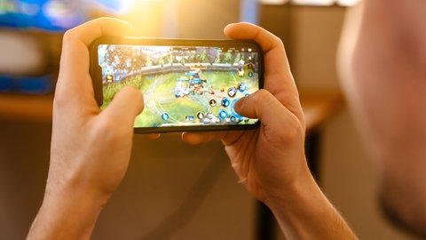Mann spielt auf Handy ein Spiel 