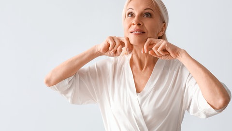 Frau macht Gesichtsyoga