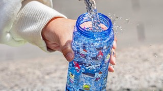 Eine Trinkflasche wird mit Wasser aufgefüllt | Richtige Hygiene: So reinigen wir unsere Trinkflaschen am besten