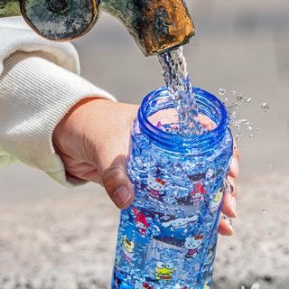 Eine Trinkflasche wird mit Wasser aufgefüllt | Richtige Hygiene: So reinigen wir unsere Trinkflaschen am besten
