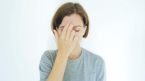 Frau drückt Akupressur-Punkt am Kopf