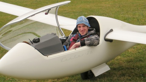 Alex sitzt im Cockpit seines Segelflugezugs, mit dem er später abgestürzt ist.  SWR1 Neuanfang: Alex überlebt den Absturz mit dem Segelflieger – die Sehnsucht nach Höhe und Weite bleibt