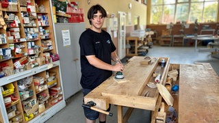 Azubi Nico Dietz steht in einer Werkstatt