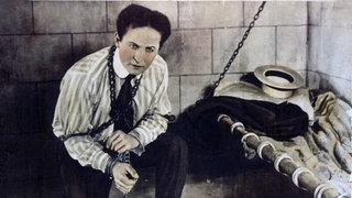 Harry Houdini gefesselt in einer Gefängniszelle, aus der er fliehen wird