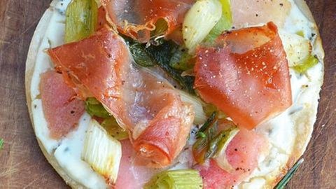 runder Flammkuchen mit speck, Äpfeln, ziegenkäsecreme und frühlingszwiebeln