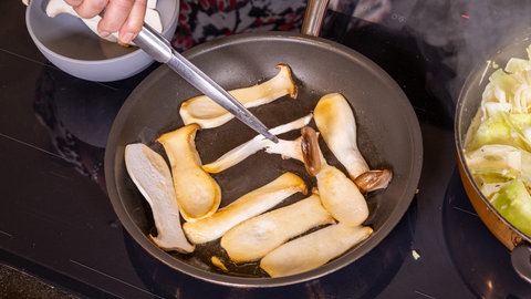 Ilzhöfer kocht für Jordi: Krautfleckerl mit Pilzen und Speck. Pilze werden in einer Pfanne angebraten.