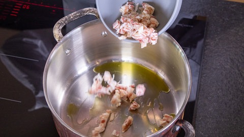 Pancetta wird mit Öl in einem Topf angebraten für eine leckeres Ragu alla Bolognese.