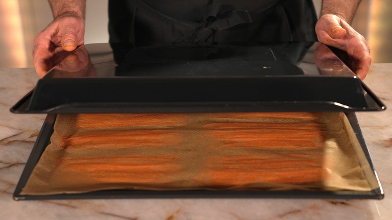Mit einem zweiten Backblech umgekehrt abdecken und im Ofen bei 200° 15–20 Minuten backen. 