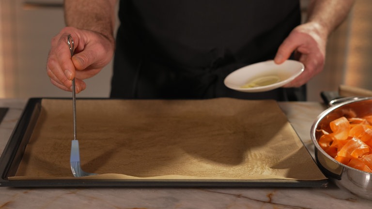 Ein Backblech mit Backpapier auslegen und mit Öl bestreichen.