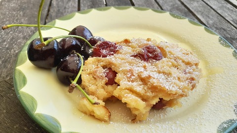Kirschmichel nach Originalrezept auf einem Dessertteller mit frischen Kirschen als Deko