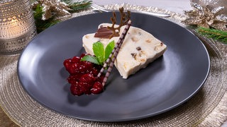 Stollenparfait, das Dessert zum Weihnachtsmenü: Der Nachtisch ist auf einem Teller dekoriert und zum Servieren bereit.