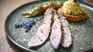 Rinder-Flanksteak mit Lupinenbratling und Bohnen auf einem Teller