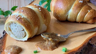 Eine Weißwurst im Brezelteigmantel.