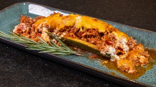 Gefüllte Zucchini: Wie im Rezept beschrieben sind die Zucchini mit Hackfleisch gefüllt, einfach überbacken und auf einem Teller angerichtet. 