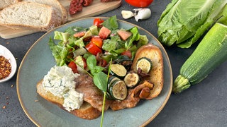 KI-Rezept: Schweinesteaks mit Pfifferlingen und Zucchini, Tomaten-Melonensalat, Kräuterfrischkäse und Röstbrot