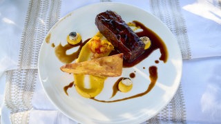 Short Ribs mit Polenta und Maispüree auf einem Teller