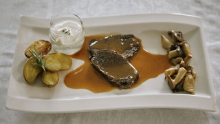 „Bison meets Angus“, Country-Potatoes, Kräuterseitlinge und Knoblauch-Dip auf einem Teller