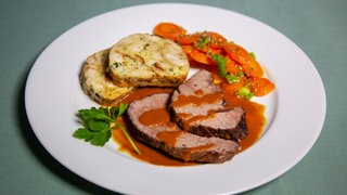 Rinderschmorbraten mit Serviettenknödel auf einem Teller