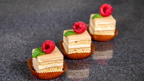 Petit Fours auf dem Marzipan mit Himbeeren verzieren