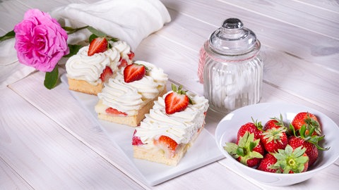 Erdbeerkuchen backen: Einfaches Rezept für Erdbeer-Amaretto-Schnitte mit Vanillecreme und Sahne.