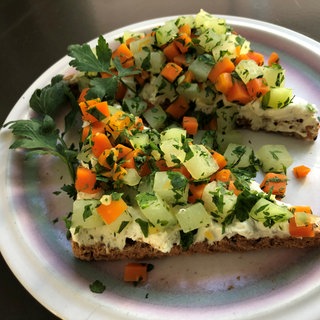 Scheibe Vollkorntoast mit Frischkäse und Gemüsewürfeln als Topping