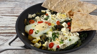 Grünes Shakshuka mit Spinat und Lauchzwiebeln