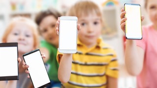 Kinder halten Smarphones. Smartphones Kinder Gefahren